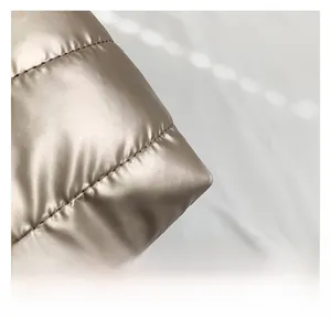 Detailed close-up of quilted champagne gold fabric with premium stitching craftsmanship