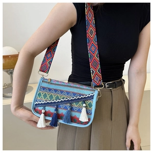 Detail of bohemian ethnic crossbody bag with colorful weaving and blue tassels