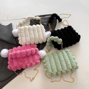Flat lay of plush chain shoulder bags in white, black, pink, and green with fur textures