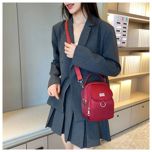 Close-up of vibrant red nylon mini shoulder bag with multi-layer zipper and wide strap