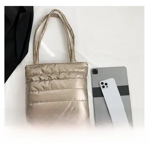 Spacious quilted tote bag in champagne gold shown with iPad for size comparison