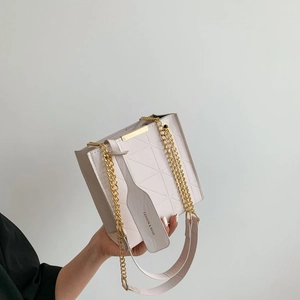 Detail of light pink quilted leather bag with gold chain strap and fashion logo tag