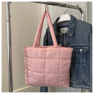 Pink quilted puffer tote bag with square stitching detail displayed on a rack