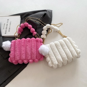 Detailed plush texture and faux fur pom-poms on pink and white quilted handbags