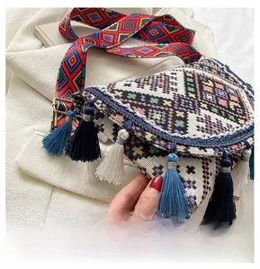 Detailed shot of ethnic woven crossbody bag with vibrant long tassels and patterned strap