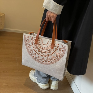 Ethnic style canvas tote bag with brown geometric print and leather handles for daily use