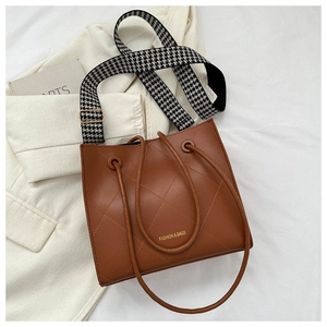 Détail du sac cabas en cuir matelassé marron avec large bandoulière à motif pied-de-poule