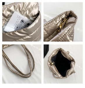 Detail of champagne gold quilted tote showing zipper and transparent card slot