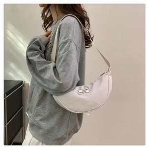 Detail view of white crescent bag with YUN QING label and adjustable nylon strap