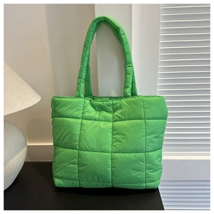 Detailed close-up of bright green quilted puffer tote bag with large square stitching