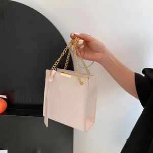 Close-up of quilted geometric texture handbag with elegant gold chain and hardware