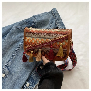 Close-up of Bohemian crossbody bag with colorful tassels and ethnic pattern wide strap