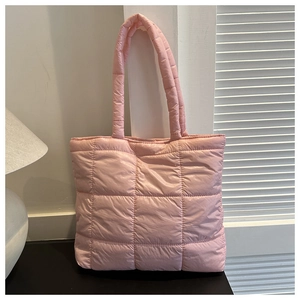 Close-up of pink quilted puffer tote bag with stitched square patterns and padded straps