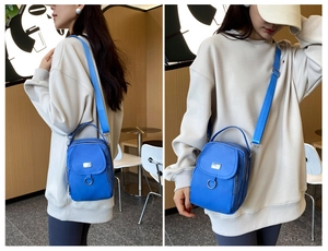 Blue nylon mini crossbody phone bag with adjustable wide strap and metal hardware detail