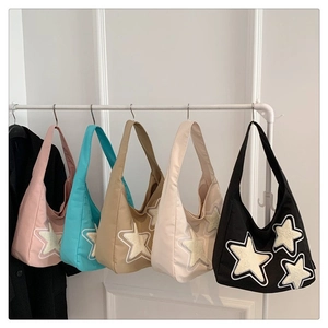 Detailed close-up showing five colorful canvas tote bags with star patchwork hanging on a rack