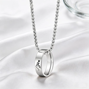 Polished silver heart signet pendant necklace on white silk background with a glass accent