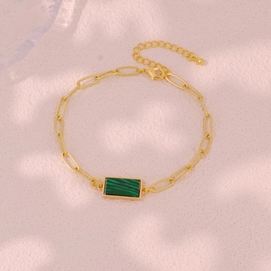 Detail of gold paperclip chain bracelet featuring a rectangular green malachite stone