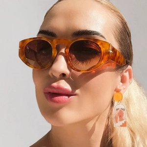 Close-up of tortoise shell retro sunglasses with tinted lenses on a female model