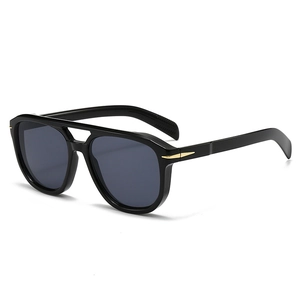 Detail of black aviator sunglasses with gold arrow metal accents and double bridge