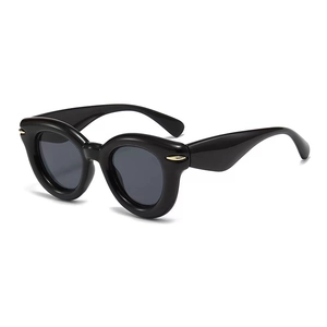 Retro round black cat-eye sunglasses with gold metal accents and dark grey lenses