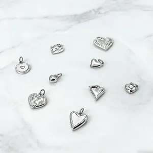 Detailed close-up of polished silver heart pendants with striped and matte textures