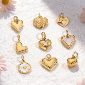 Detailed view of 14K gold plated heart pendants with mother of pearl inlay and textures