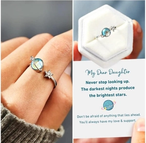 Detailed view of silver star and planet adjustable ring in a velvet jewelry gift box