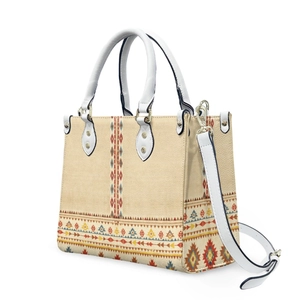 Detailed close-up of tribal geometric prints and golden metal hardware on a cream tote bag