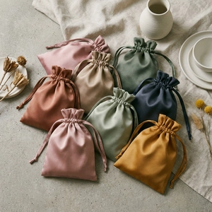 Detailed flat lay of colorful silk satin drawstring pouches in various Morandi tones