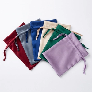 Macro detail of satin drawstring bags in various colors showing smooth silk texture
