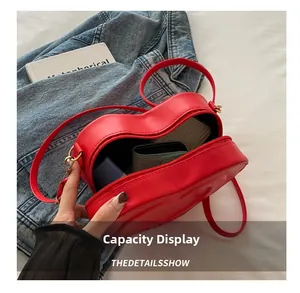 Detail view of red heart-shaped shoulder bag capacity with phone and accessories
