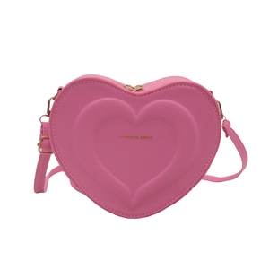 Pink heart-shaped PU leather crossbody bag with embossed patterns and adjustable strap