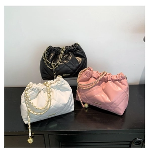 Three quilted chain bags in black, white, and pink with drawstring closure detail