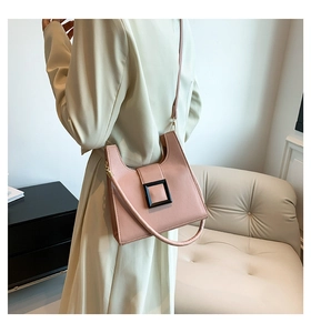 Detail of light pink leather crossbody bag with bold black square buckle design