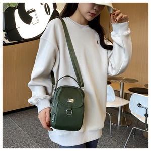Detail of army green nylon crossbody phone bag with multi-layer zippers and wide strap