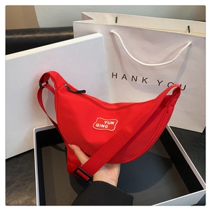 Detail of red crescent nylon waist bag with adjustable strap and YUN QING logo