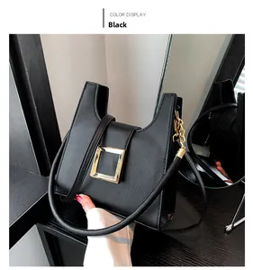 Close-up of black crossbody bag featuring lychee texture and golden square buckle