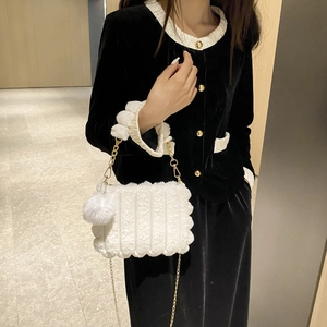 Chic white faux fur handbag with vertical quilting, gold chain strap, and plush ball charm
