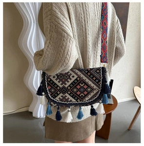 Detailed view of bohemian woven crossbody bag with colorful ethnic patterns and long tassels