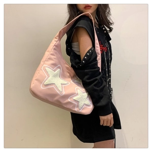 Close-up of pink Y2K shoulder bag featuring a white plush star patch and canvas texture