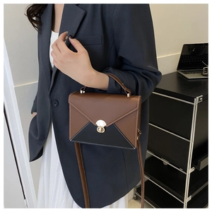 Détail du sac à main bicolore avec fermoir doré et surpiqûres blanches contrastées
