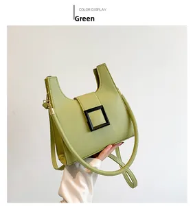 Detailed macro view of a green textured leather handbag with a black square buckle decoration