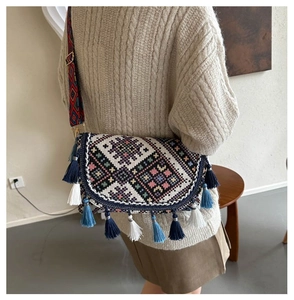 Detailed view of bohemian crossbody bag with ethnic embroidery and colorful tassels