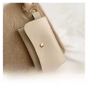 Close-up of beige lychee leather card holder and khaki faux fur bag with gold hardware