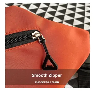 Close-up of smooth zipper and triangular pull on orange canvas crossbody bag
