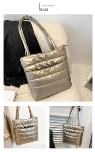 Detailed view of large quilted puffer tote bag in metallic gold with shoulder straps