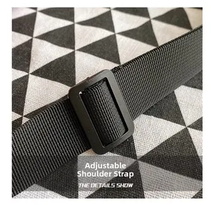 Macro detail of adjustable black woven nylon shoulder strap with plastic buckle