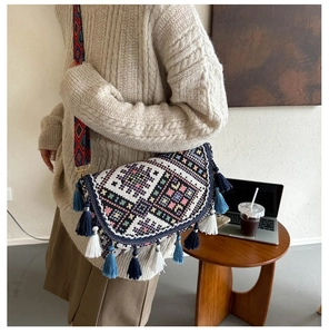 Detail of bohemian woven crossbody bag featuring colorful tassels and ethnic print strap