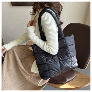 Detail of the black quilted puffer tote bag showcasing thick padding and soft glossy texture