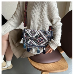 Close-up of geometric jacquard pattern shoulder bag with tassel details and ethnic strap